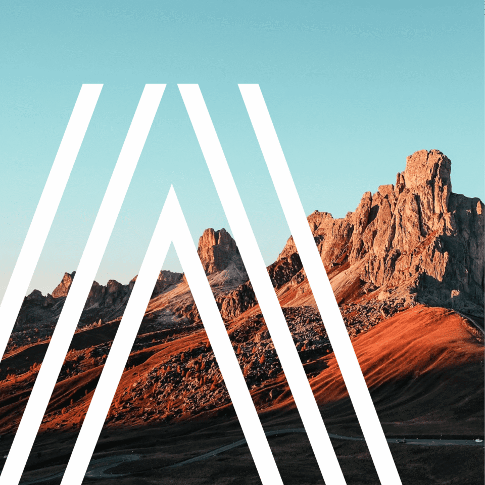 Mountain landscape with jagged peaks under a clear sky. White geometric lines overlay the image, forming a series of triangles.