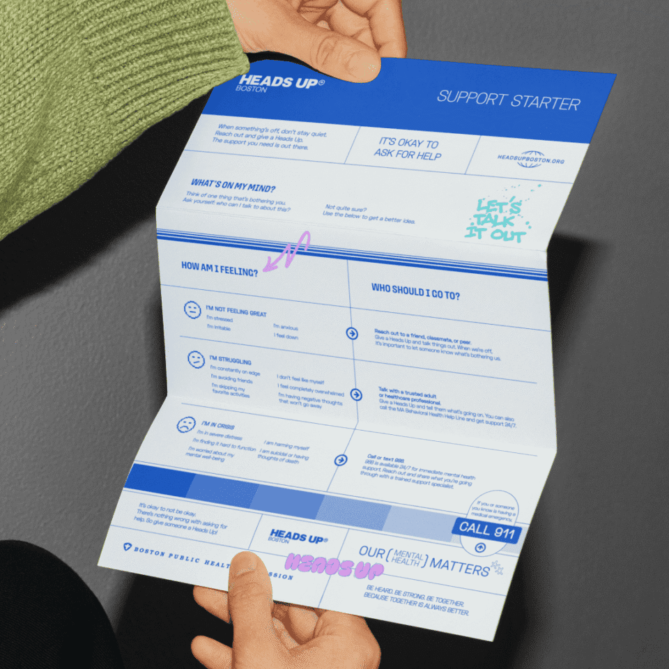 Person holding a leaflet titled "Support Starter" with sections on mental health support and encouragement to seek help.