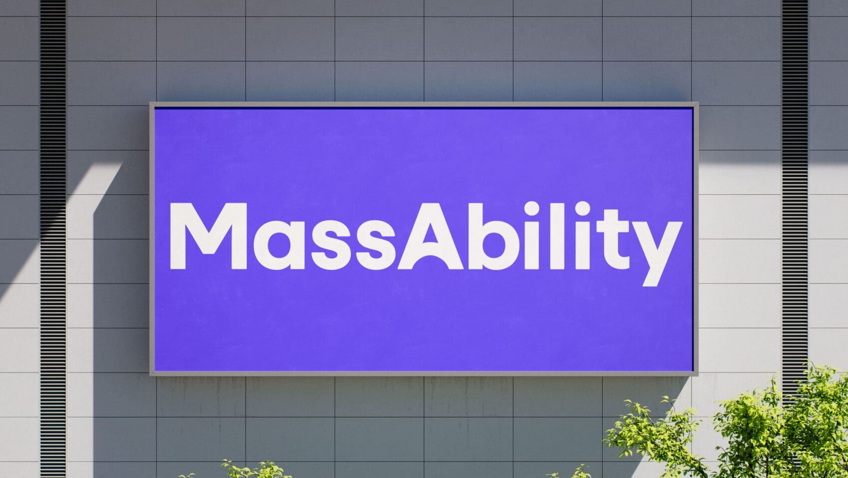 A large purple sign on a building facade displays the word "MassAbility" in white text, with some green foliage visible below.