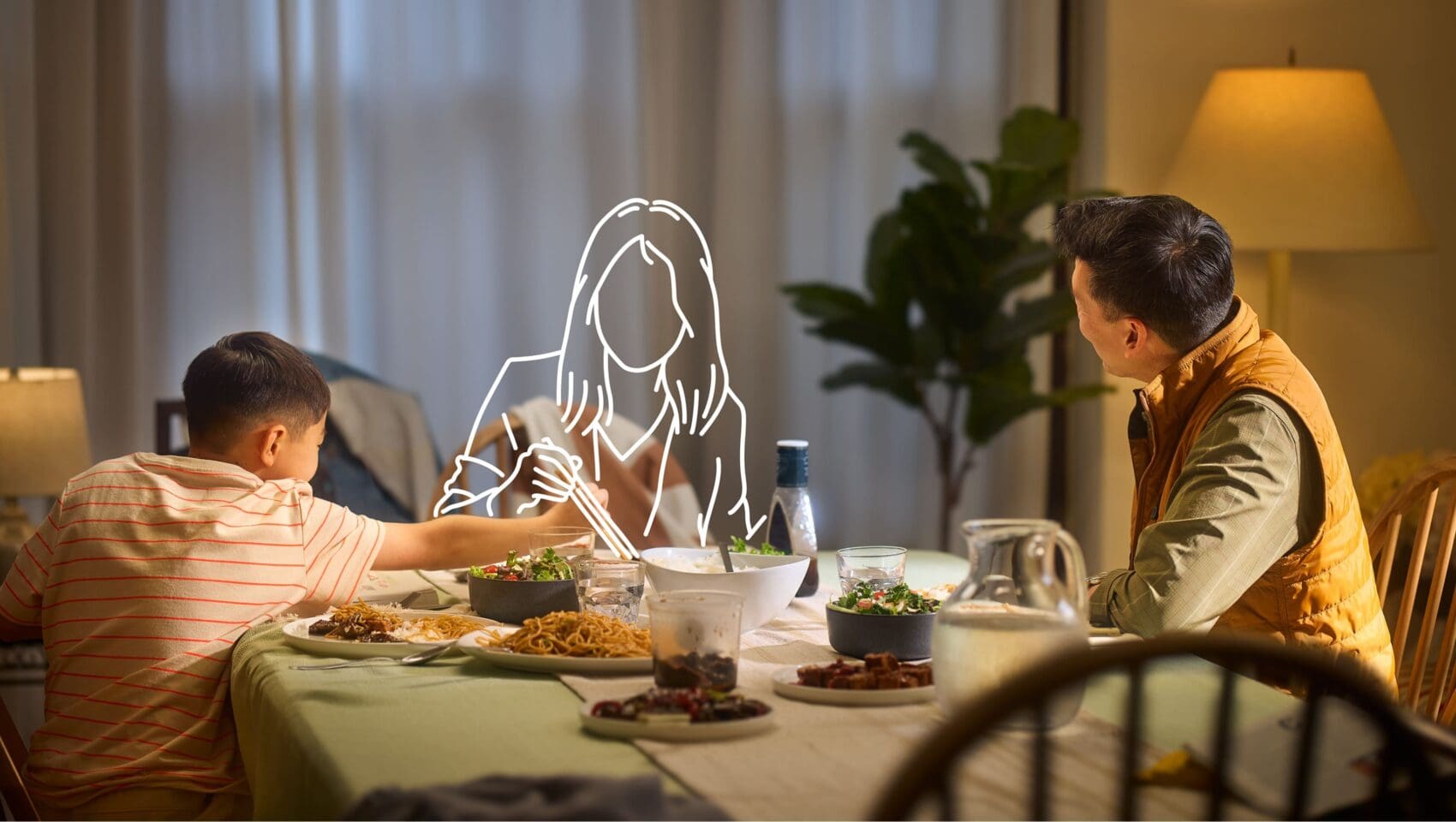 A man and a boy eat at a dinner table; an illustrated outline of a woman sits between them, suggesting her absence.
